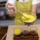 caucasian woman kitchen makes chia puddings with mango jam desert made almond milk chia seeds cocoa mango jam granola 80x80