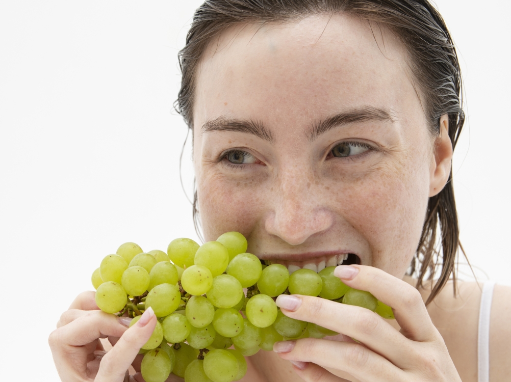 Djevojka zagrlizla bijelo grožđe